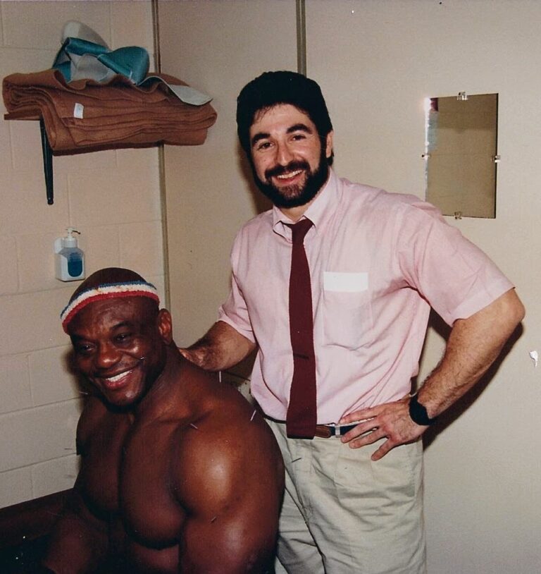 Dr. Steve Segal performing acupuncture treatment for a professional athlete backstage, demonstrating his experience combining sports chiropractic and acupuncture therapy.